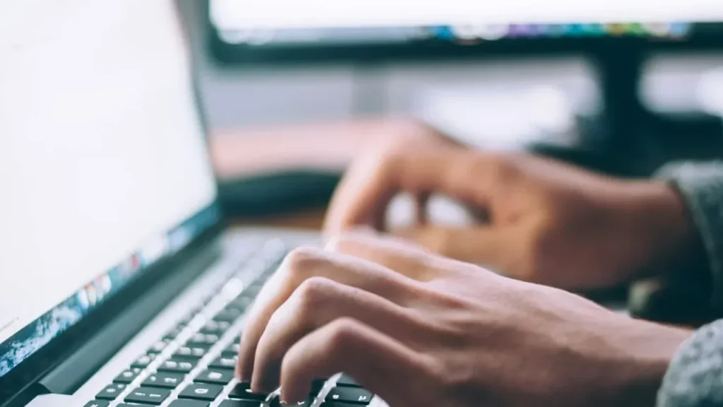 Professional hands typing at a laptop